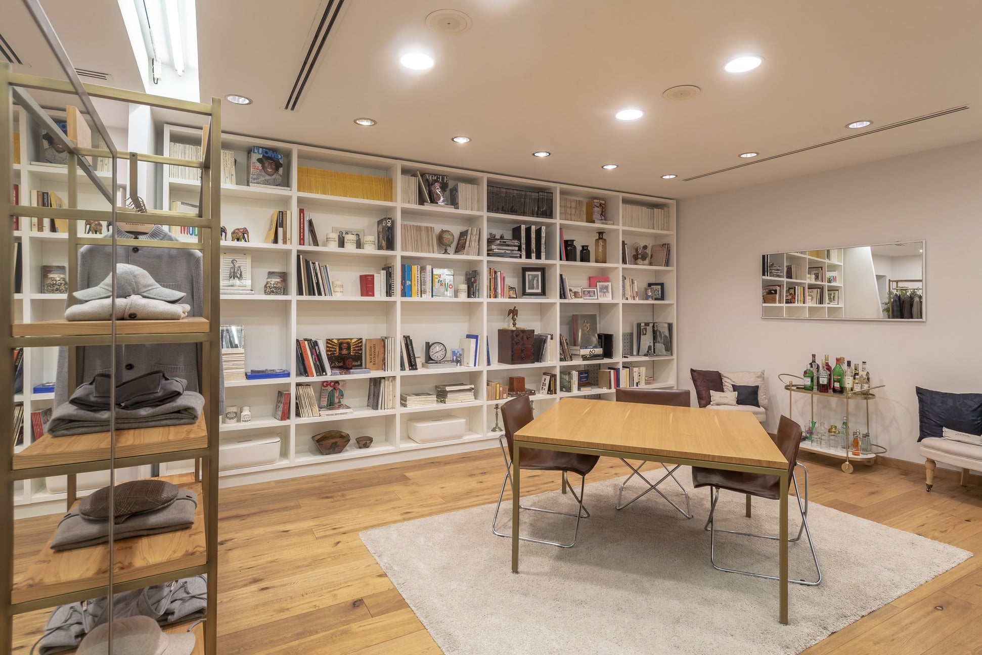 Vista su un tavolo e una grande libreria all'interno degli spazi di Maurizio Baldassari in Brera